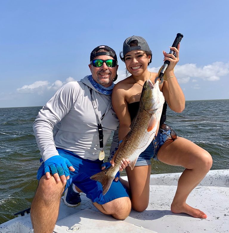 Capt. Dave Edwards with a guest and her redfish on his boat