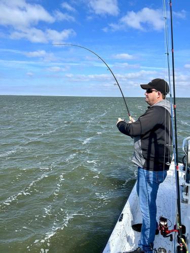 Angler with a bent rod fighting a fish