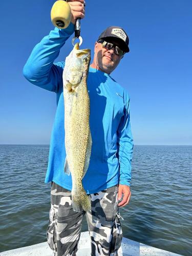 Angler holding a big speckled trout