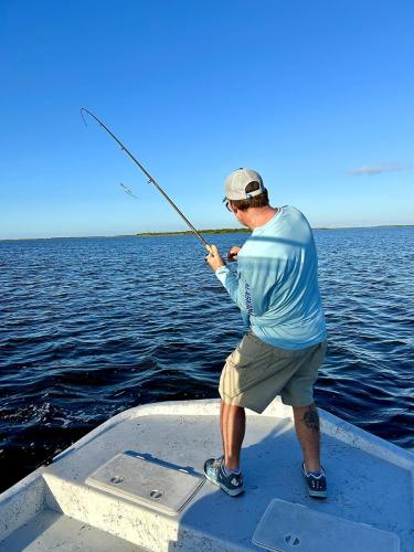 Angler fighting a fish from the bow of Capt. Dave’s boat