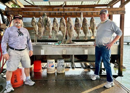 Two anglers with the day’s catch on the rack