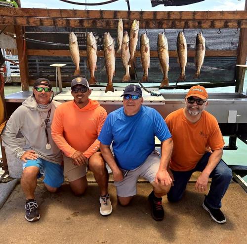 Group of four anglers with their limit of redfish and trout