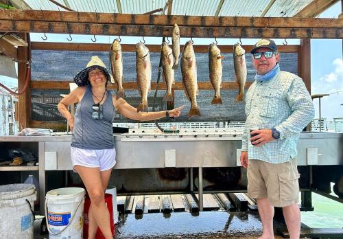 Anglers with a rack of redfish and trout